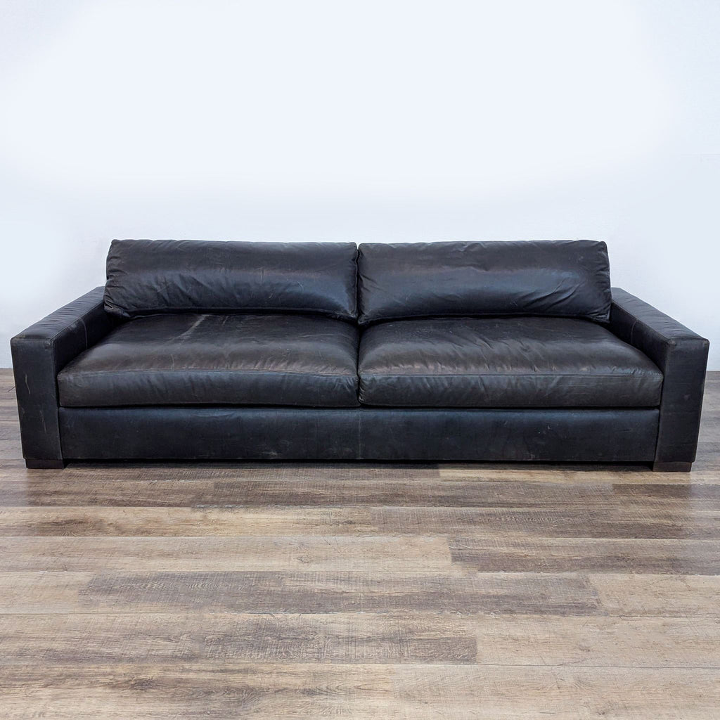 Three-seater leather sofa with a sturdy wooden frame and sleek design.