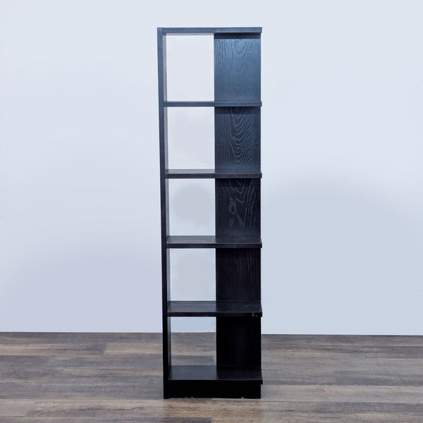 Black vertical bookshelf with five shelves, standing on wooden flooring.