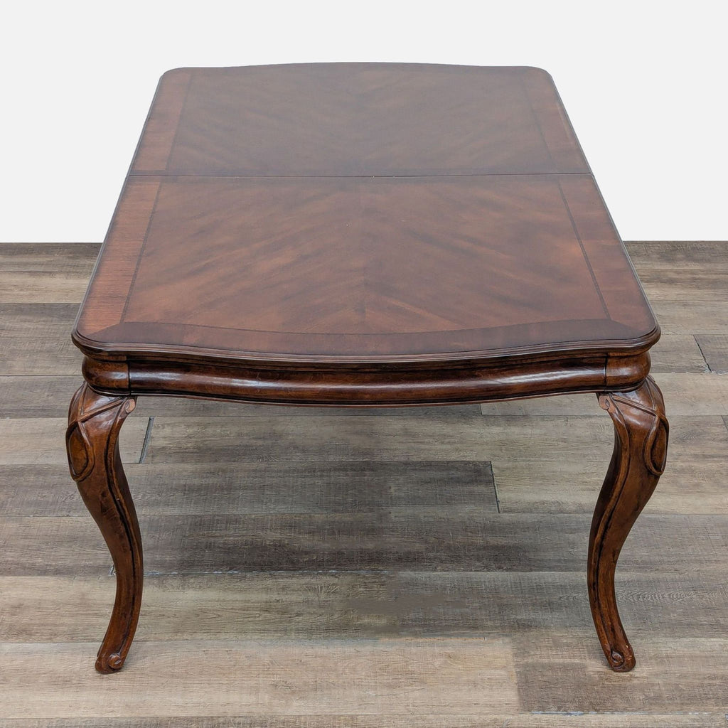 Reperch table with intricate cabriole legs, expandable from 72 to 96 inches with included inserts.