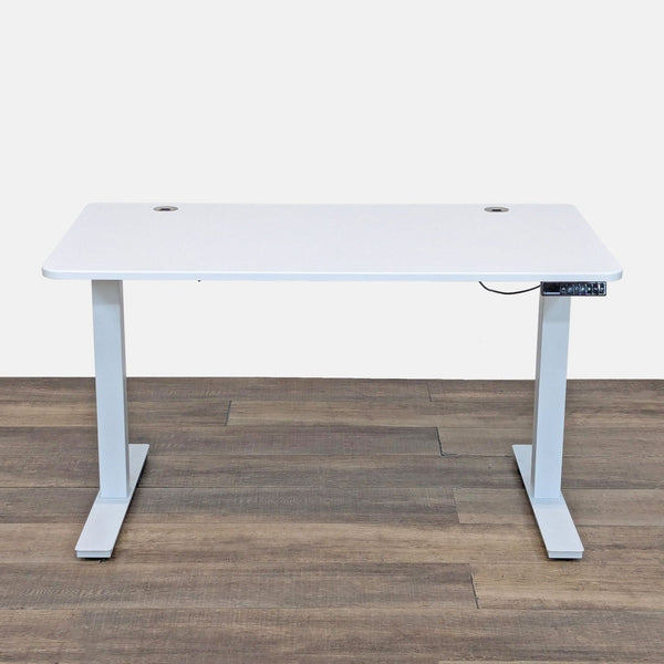 Adjustable desk with white top and metal legs, featuring cord management and remote.