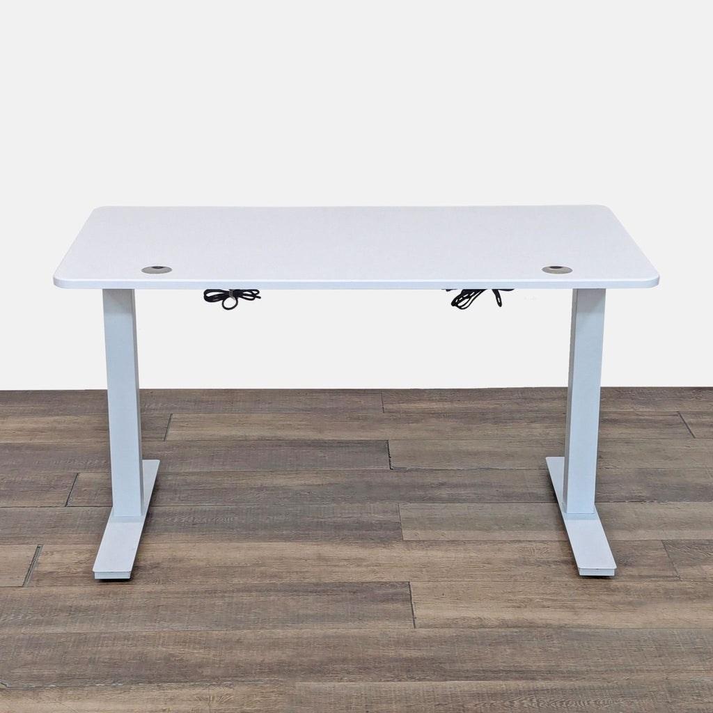 Height-adjustable Autonomous desk with metal legs, white surface, and remote control.
