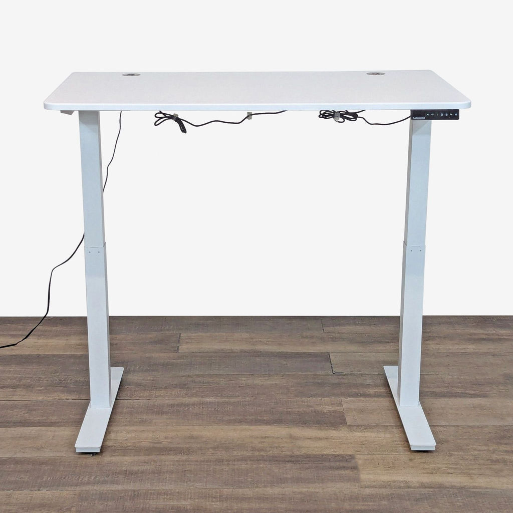 White laminate desk with programmable height, T-legs, and built-in cord management.