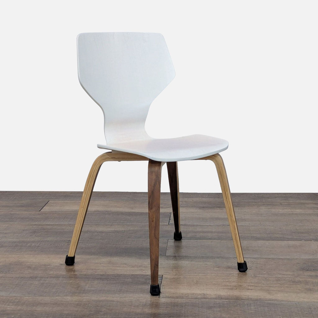 3. Side angle of a white Room & Board dining chair showing its molded plywood seat and tapered wood legs.