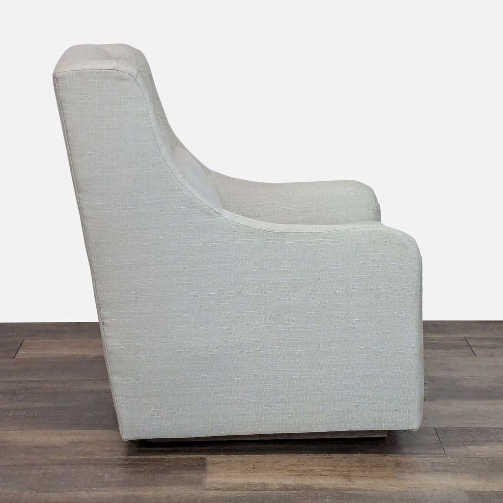 Side view of a Pottery Barn Kids lounge chair with sloped arms and wooden glide base.