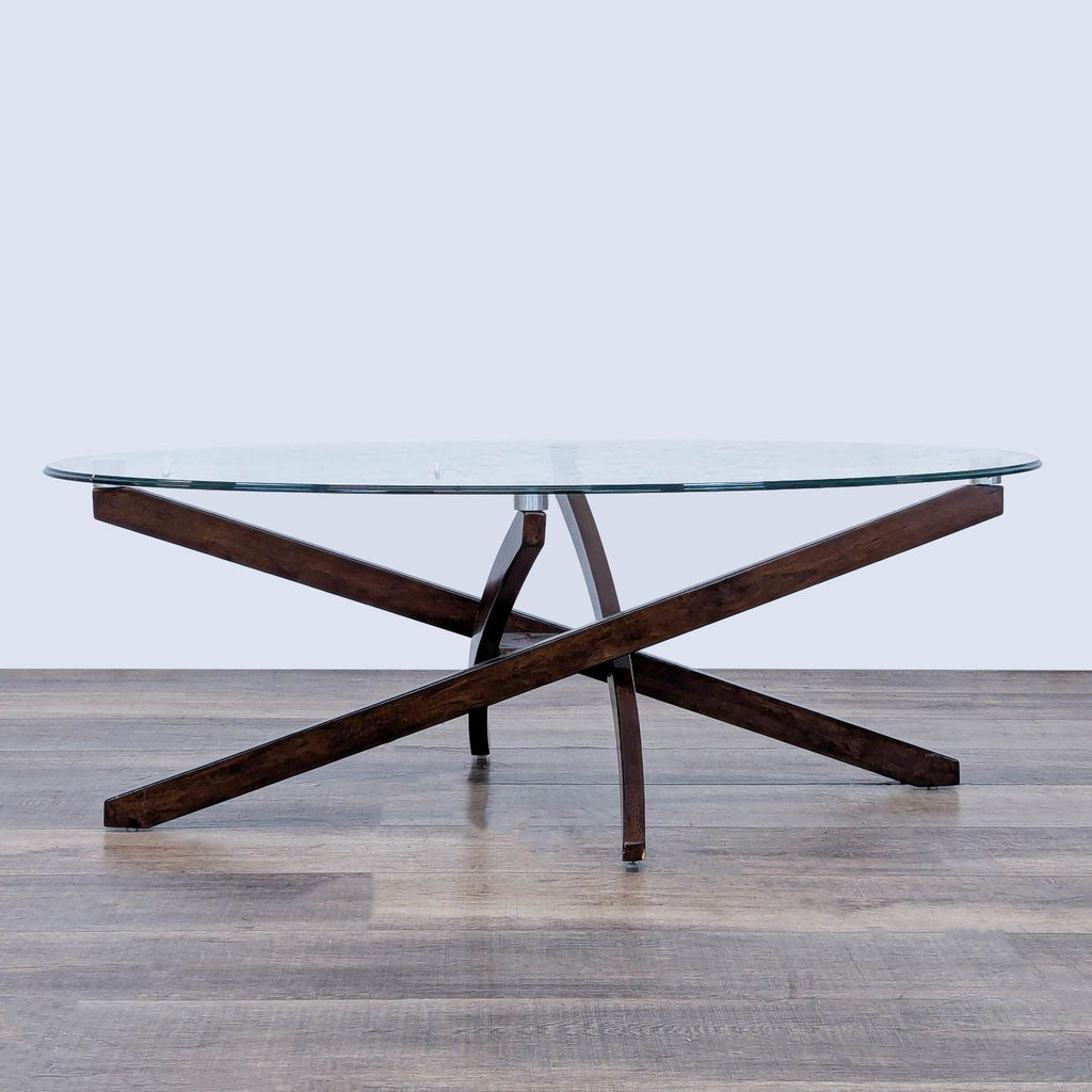 Mid-Century style coffee table with oval glass top and espresso strut base.