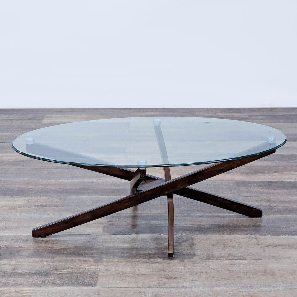 Oval glass coffee table with a dark wood base, inspired by Mid-Century design.