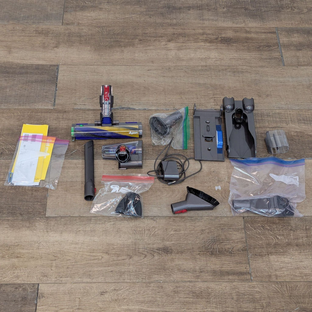 Dyson vacuum and accessories laid out on the floor.