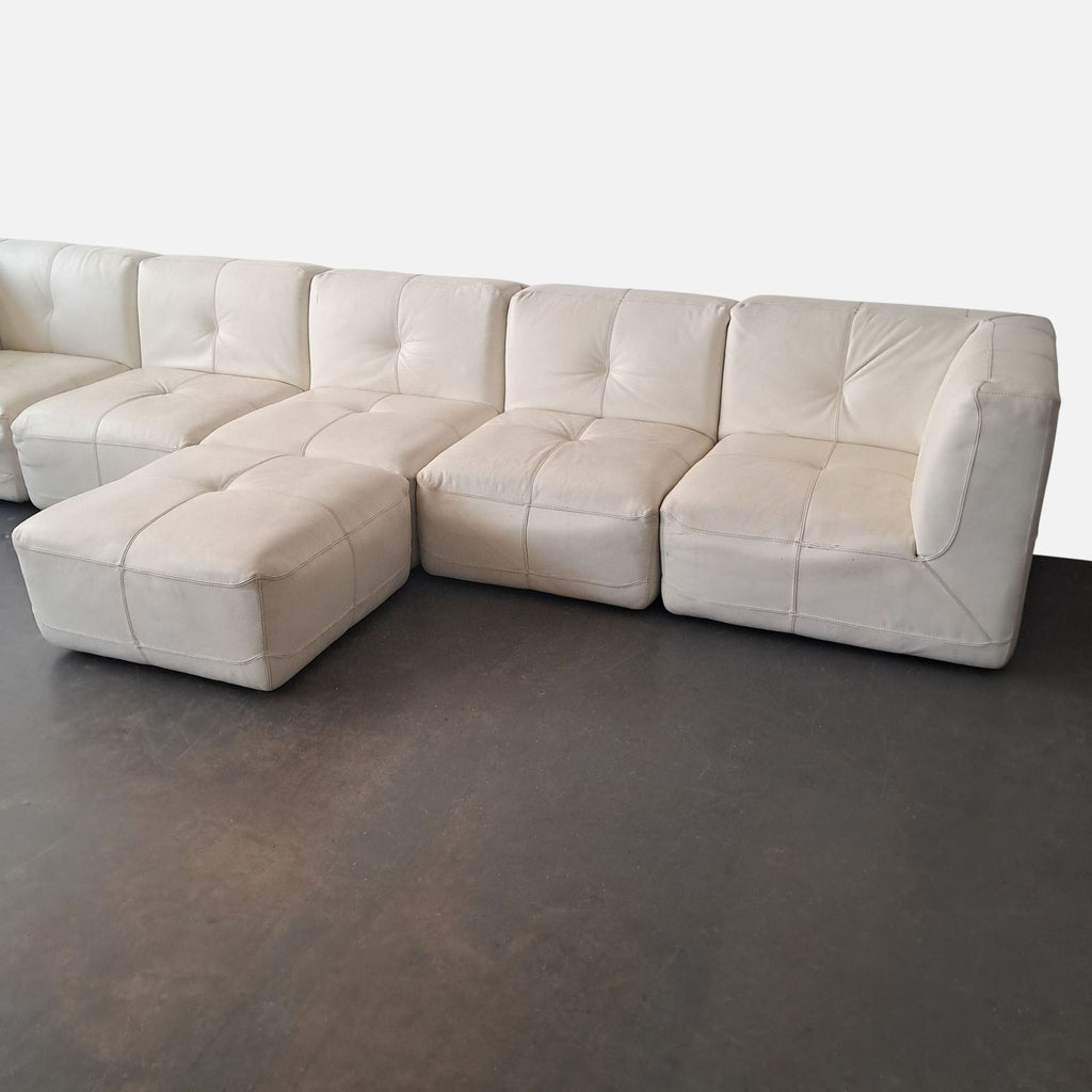 3. Modern white leather sectional by Chateau D’ax with three seat modules, two corner modules, and a matching ottoman.