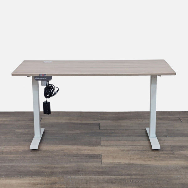 Adjustable standing desk with digital control on wood floor.