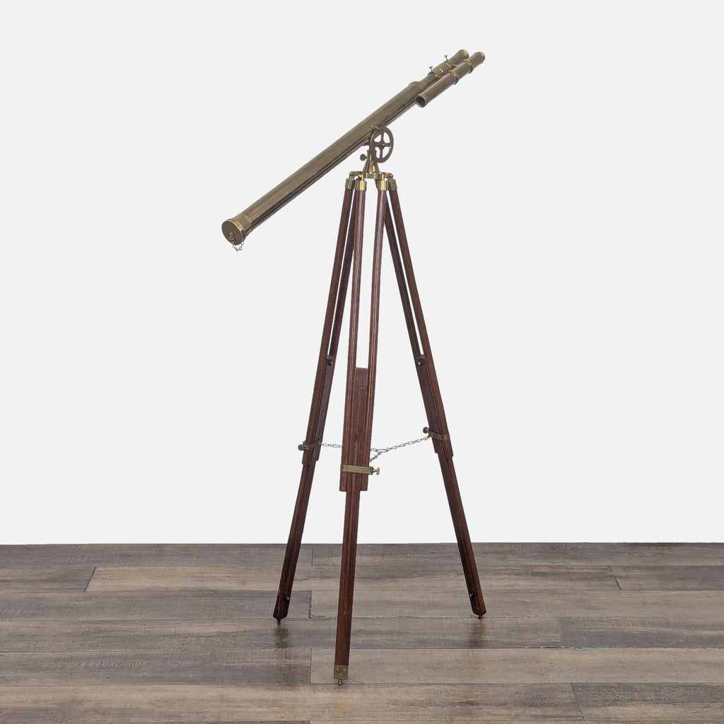Antique-style brass telescope on adjustable wooden tripod with brass chain.