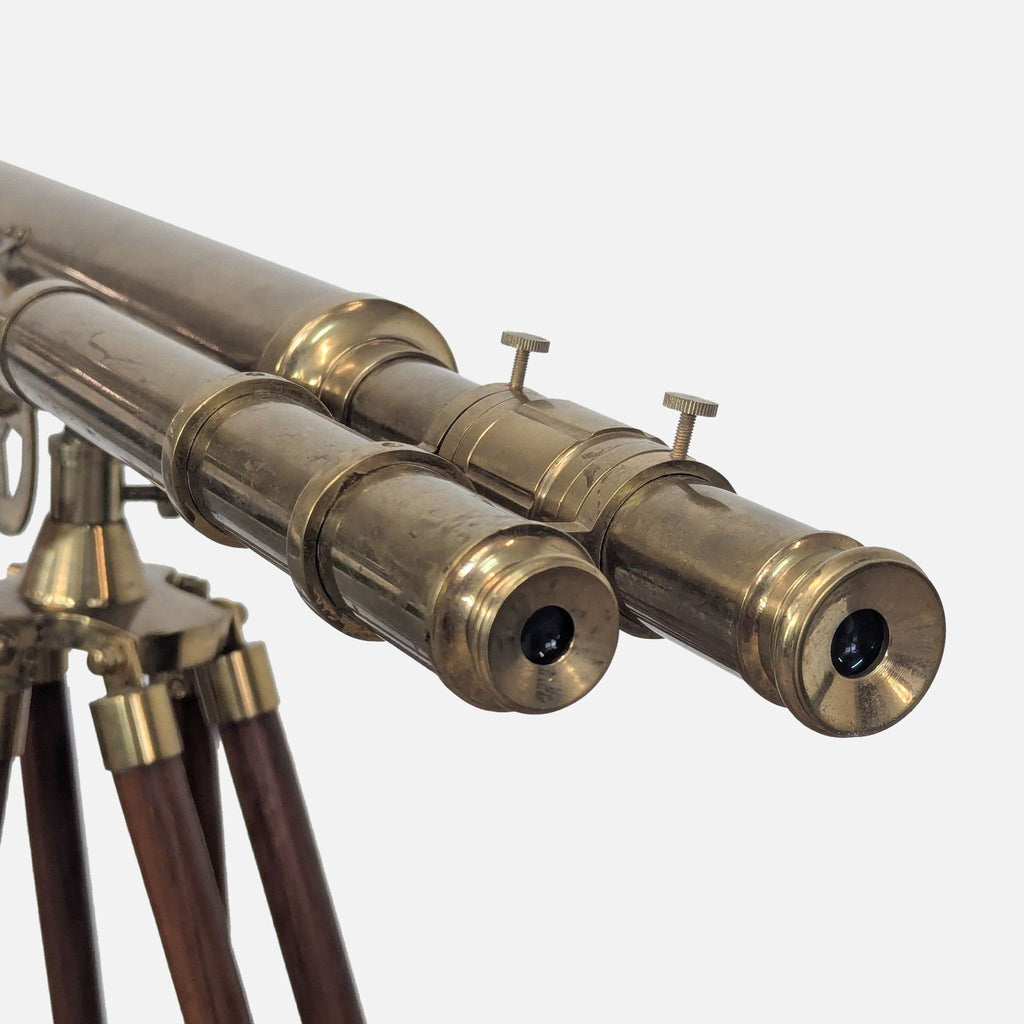 Close-up of brass telescope lenses on wooden tripod.