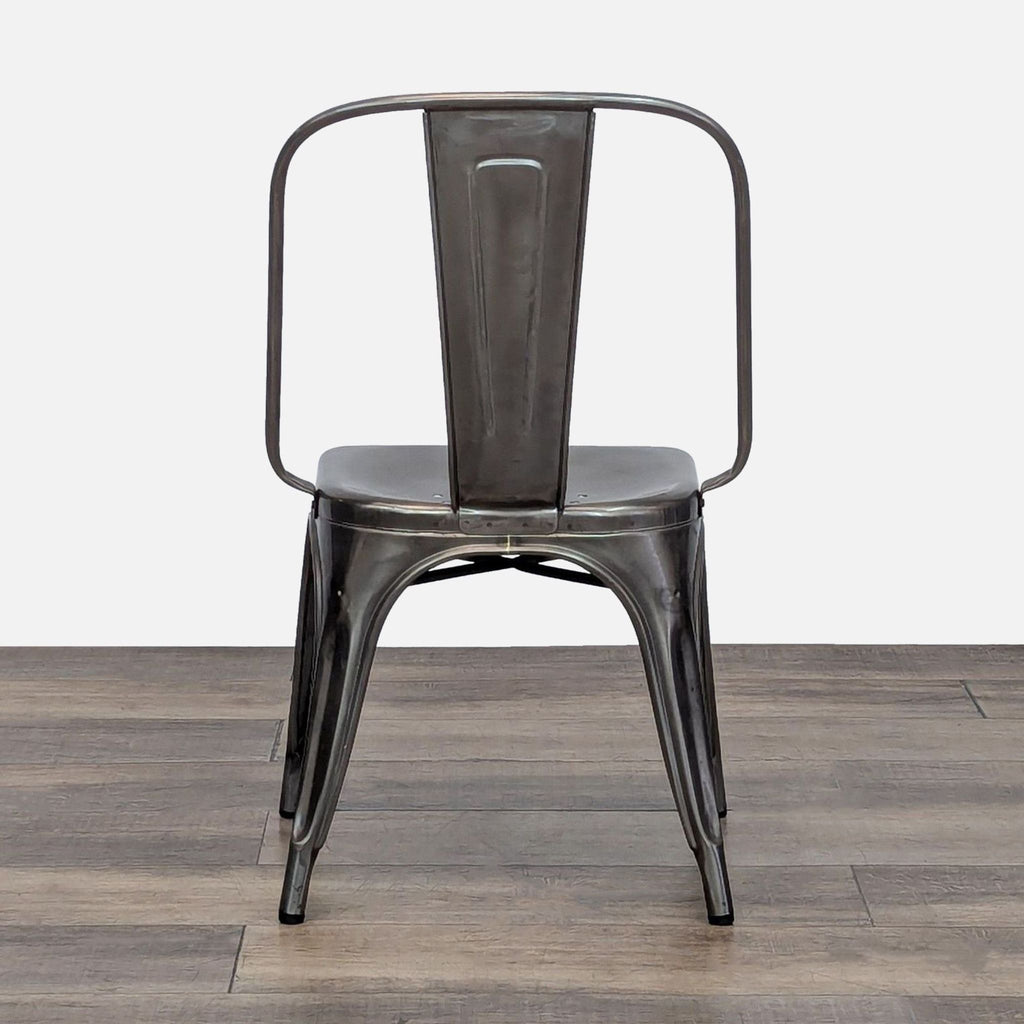 Back view of a modern, metallic Reperch dining chair against a wooden surface.