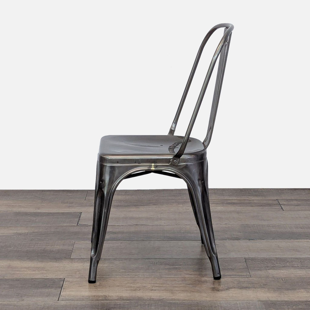 Side view showcasing the curved backrest of a Reperch metal dining chair on wood.