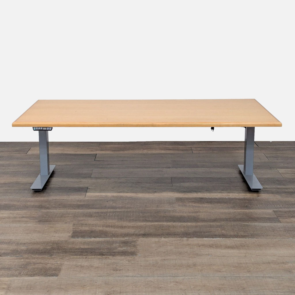 Reperch sit-stand desk with wood finish and metal legs at low height.