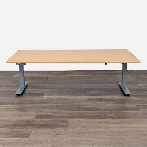 Reperch sit-stand desk with wood finish and metal legs at low height.