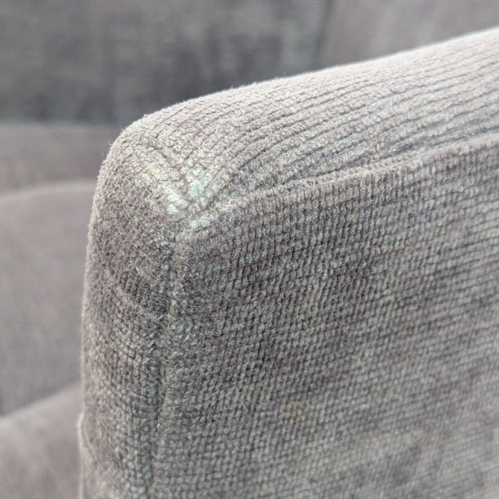 Close-up of the textured upholstery on the chair's armrest.