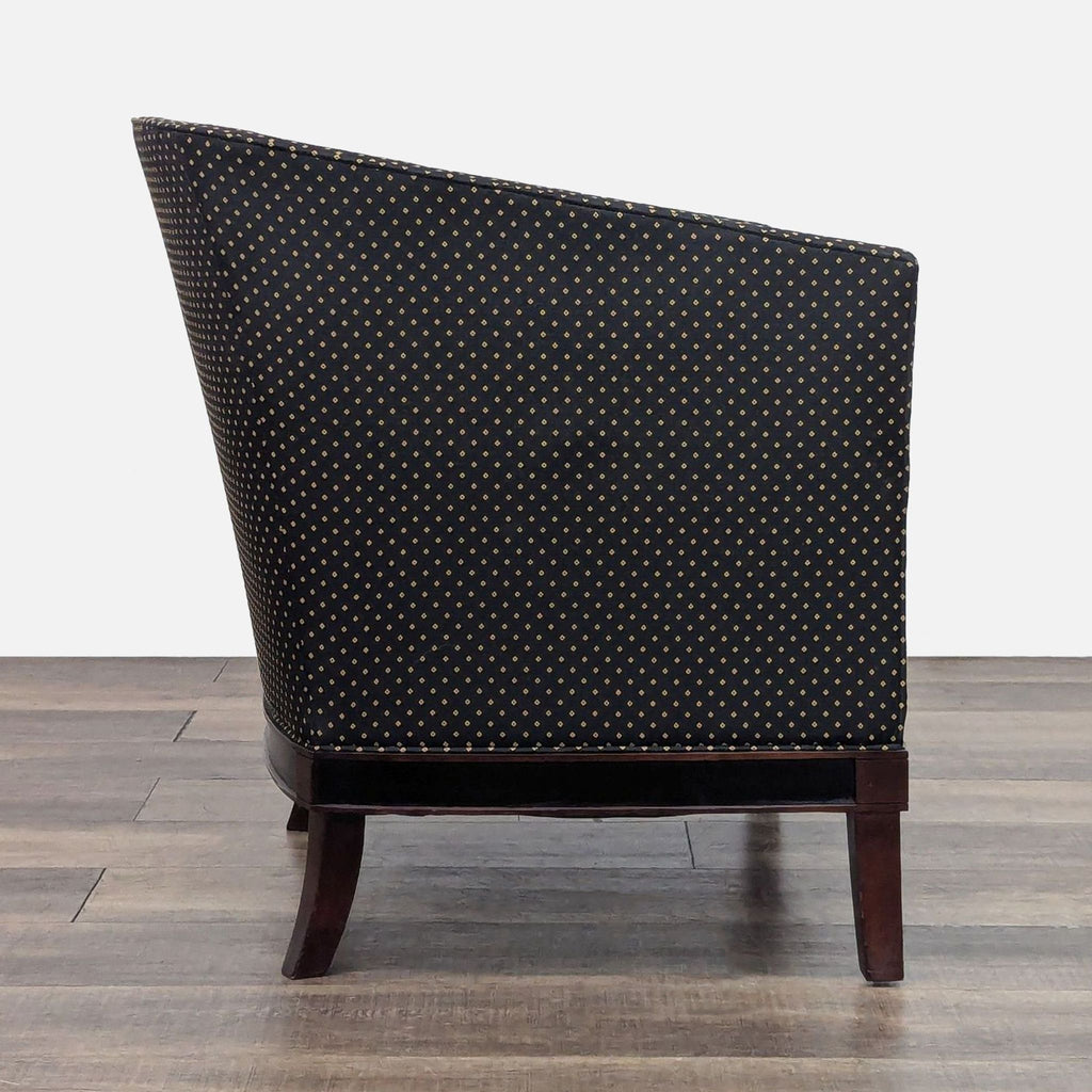 Side profile of a black upholstered lounge chair with diamond pattern and dark wood legs.