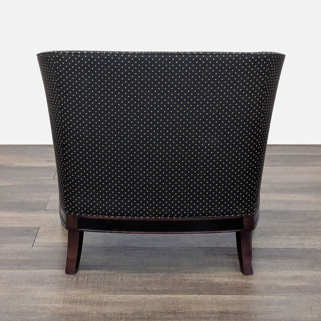 Rear view of a black lounge chair, featuring diamond-stitched black fabric and wooden legs.