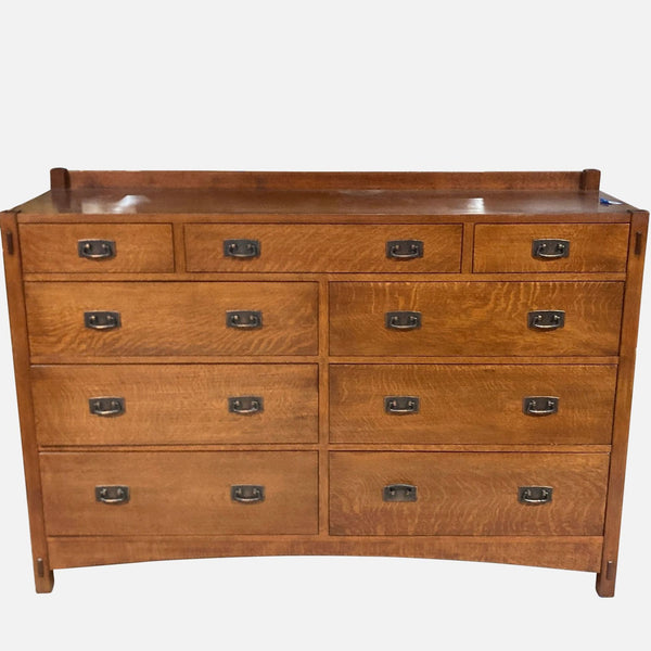 Solid wood Stickley dresser with nine deep drawers and metal pulls.