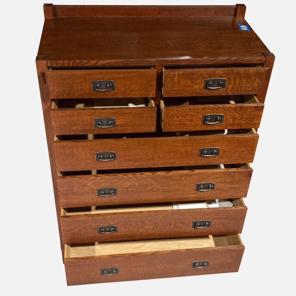 Open view of Stickley dresser showing eight wooden drawers.