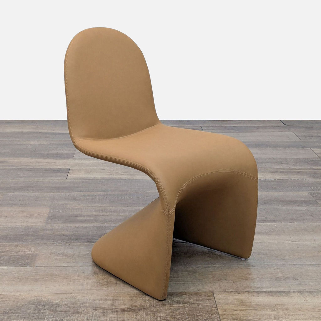 Angled view showcasing a tan chair’s smooth curves in vegan leather on a wooden floor.