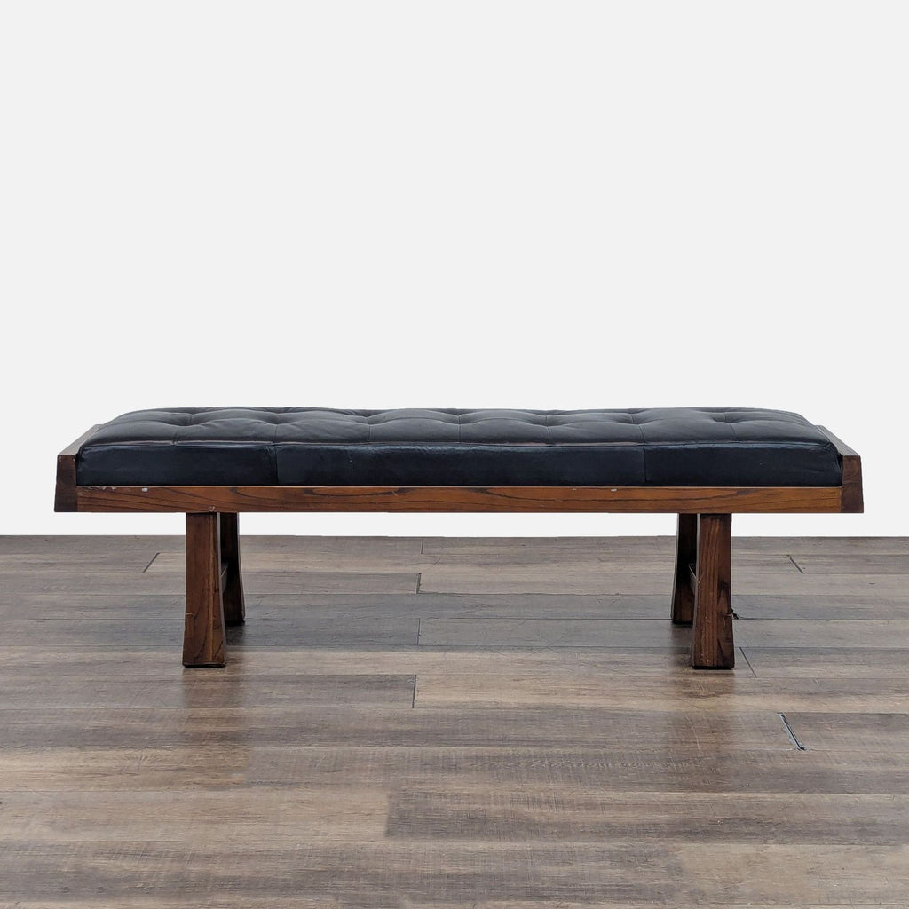 1. Black-cushioned bench with wooden legs, viewed from the front.