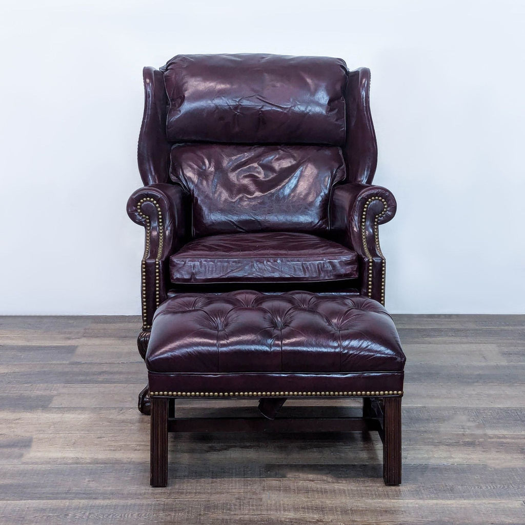 1. Leather chair with ottoman, rolled arms, and carved feet by Hancock & Moore.