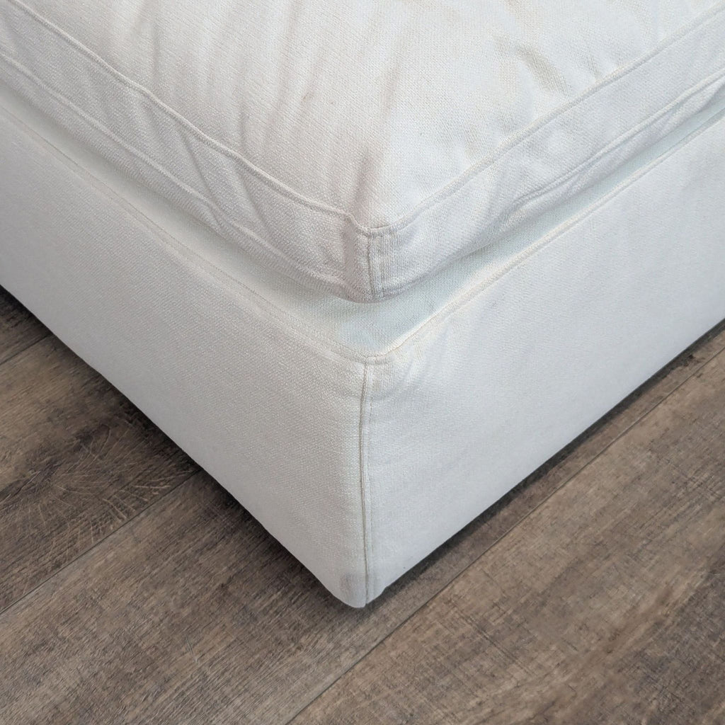 Close-up of a textured beige RH ottoman corner detail.