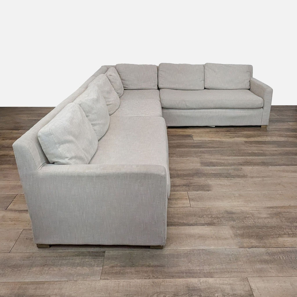 Light gray sectional sofa featuring track arms, arranged on a wood floor.