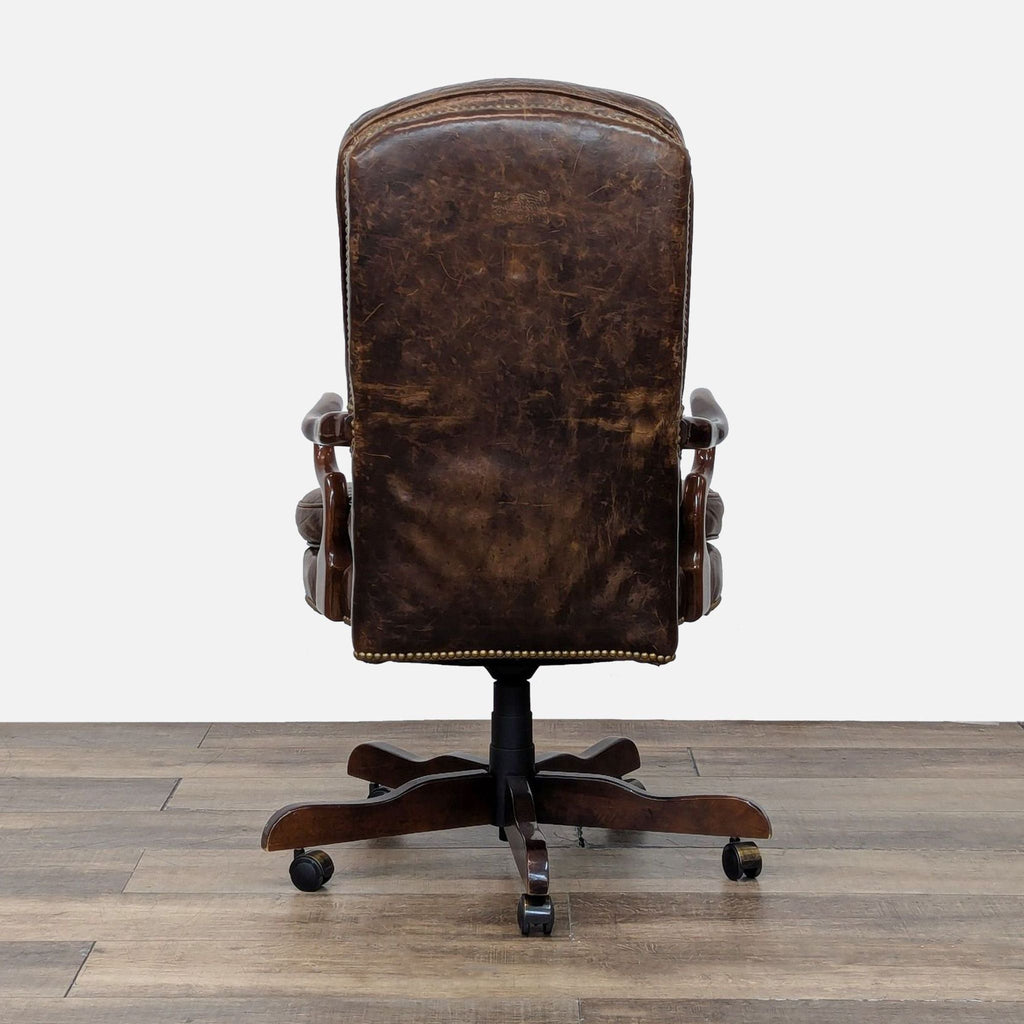 Back view of a leather chair by Century Furniture, showing detailed wood base and casters.