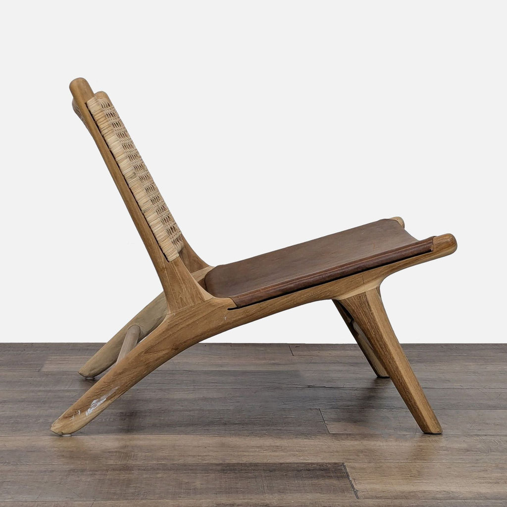 Handcrafted lounge chair featuring a teak frame and leather seat.