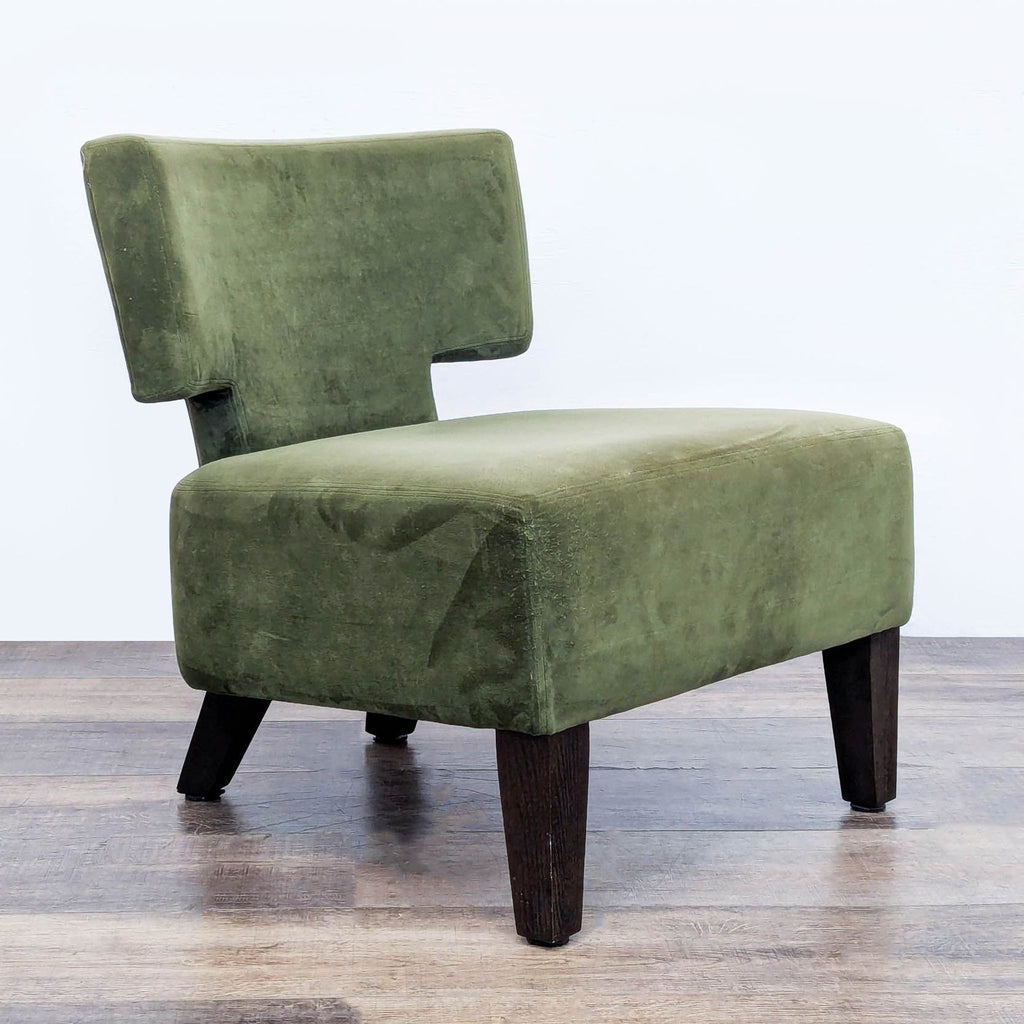 Angled view of a green West Elm slipper chair featuring wood legs.
