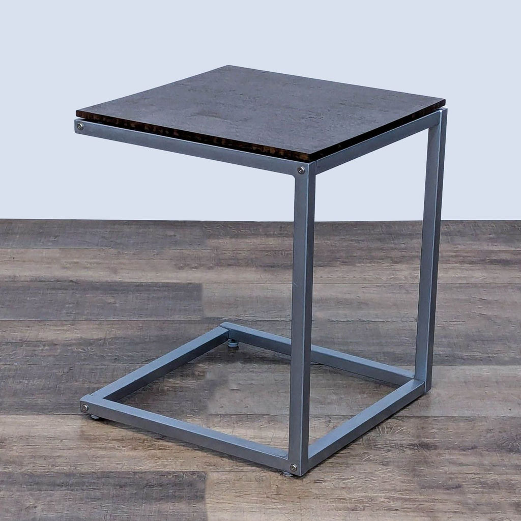 Elegant C-shaped side table by Reperch, combining a metal frame with a dark wooden surface.