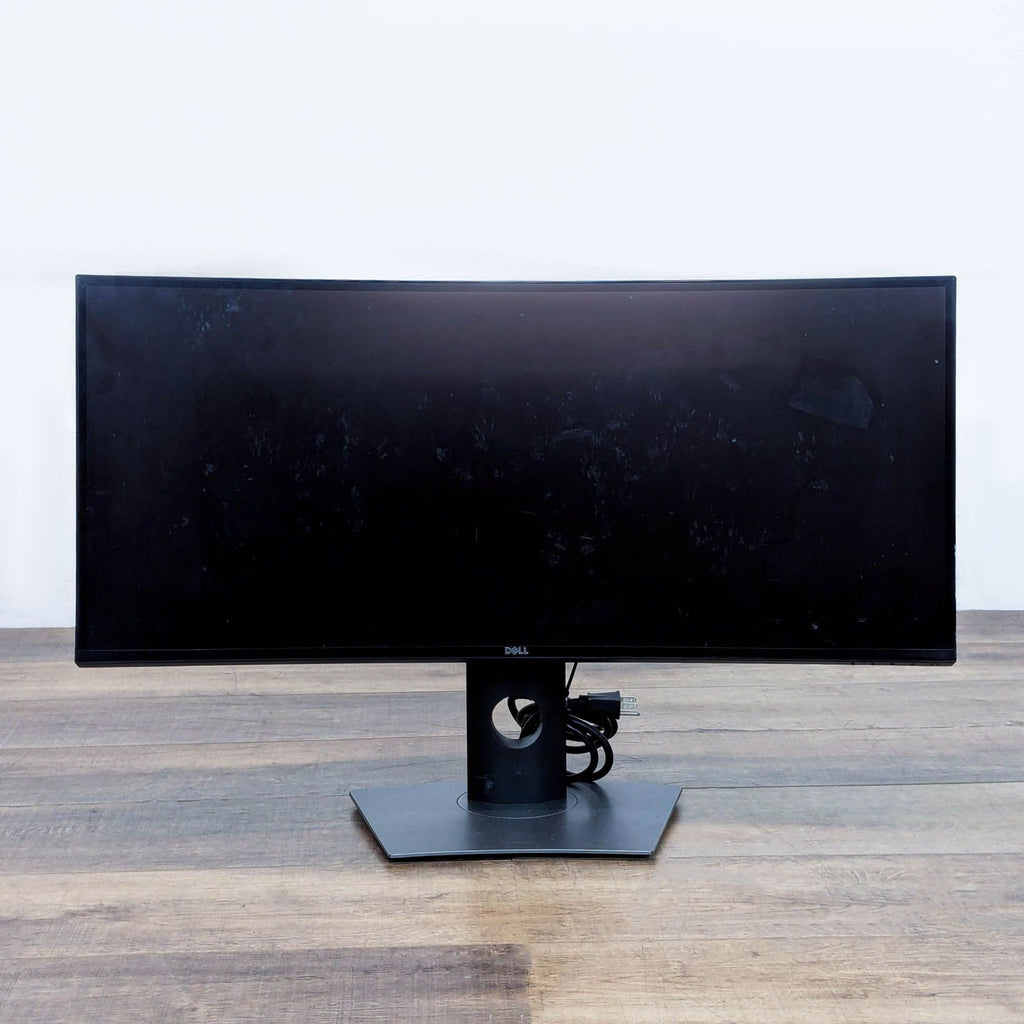 Dell curved monitor on a wooden surface, emphasizing its sleek design and vibrant display.