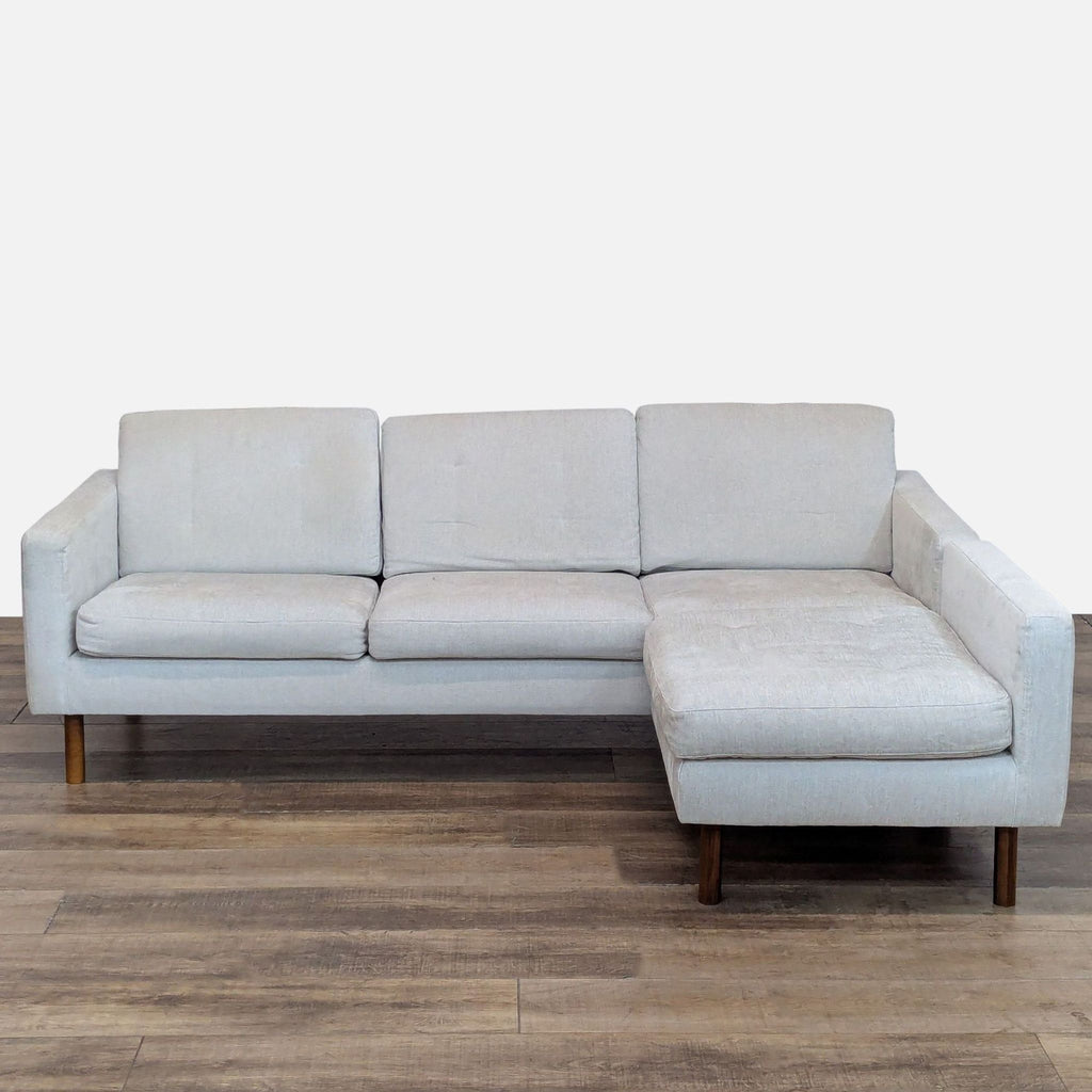 Sleek 3-seat sofa with light fabric, walnut legs, and a movable extended seat.