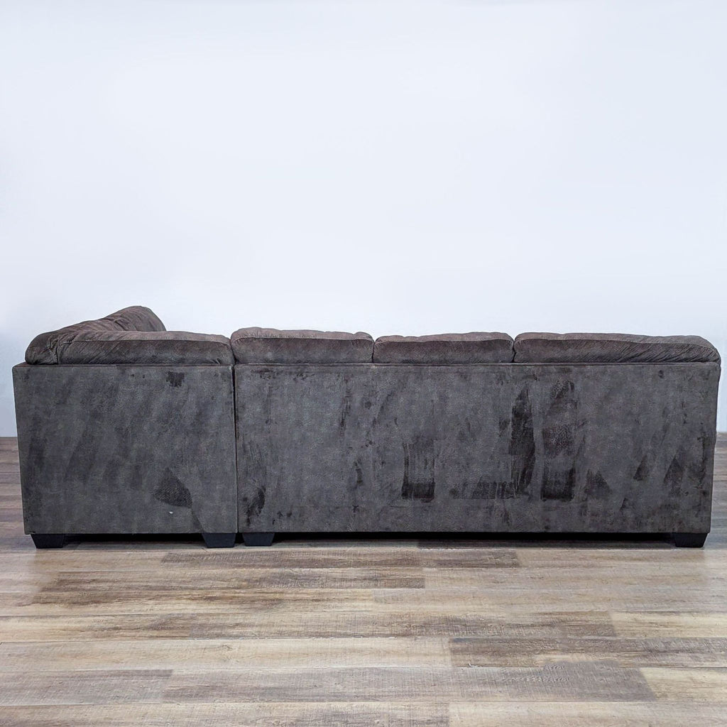 Back view of a tufted sectional sofa, showcasing clean lines and sturdy design.