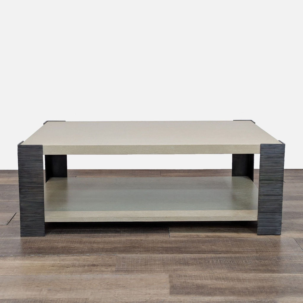 Transitional coffee table with dark iron legs and a bottom shelf, in Drift Oak finish.