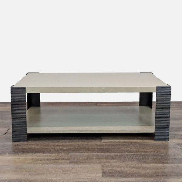 Transitional coffee table with dark iron legs and a bottom shelf, in Drift Oak finish.