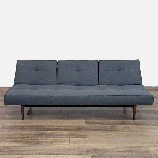 Mid-century sleeper sofa with tufted cushions and tapered legs, shown upright.