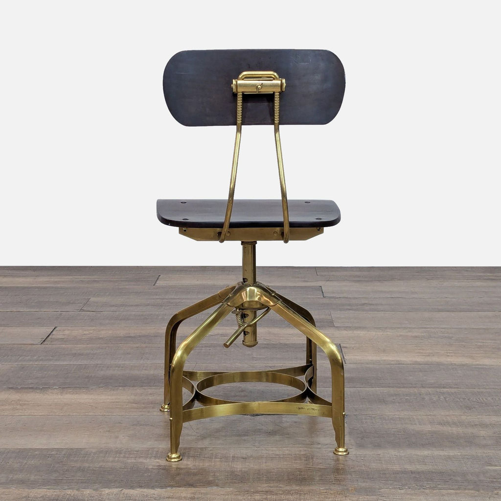 Industrial-style chair, featuring a bent steel base, wood seat, and swivel mechanism in a brass finish.