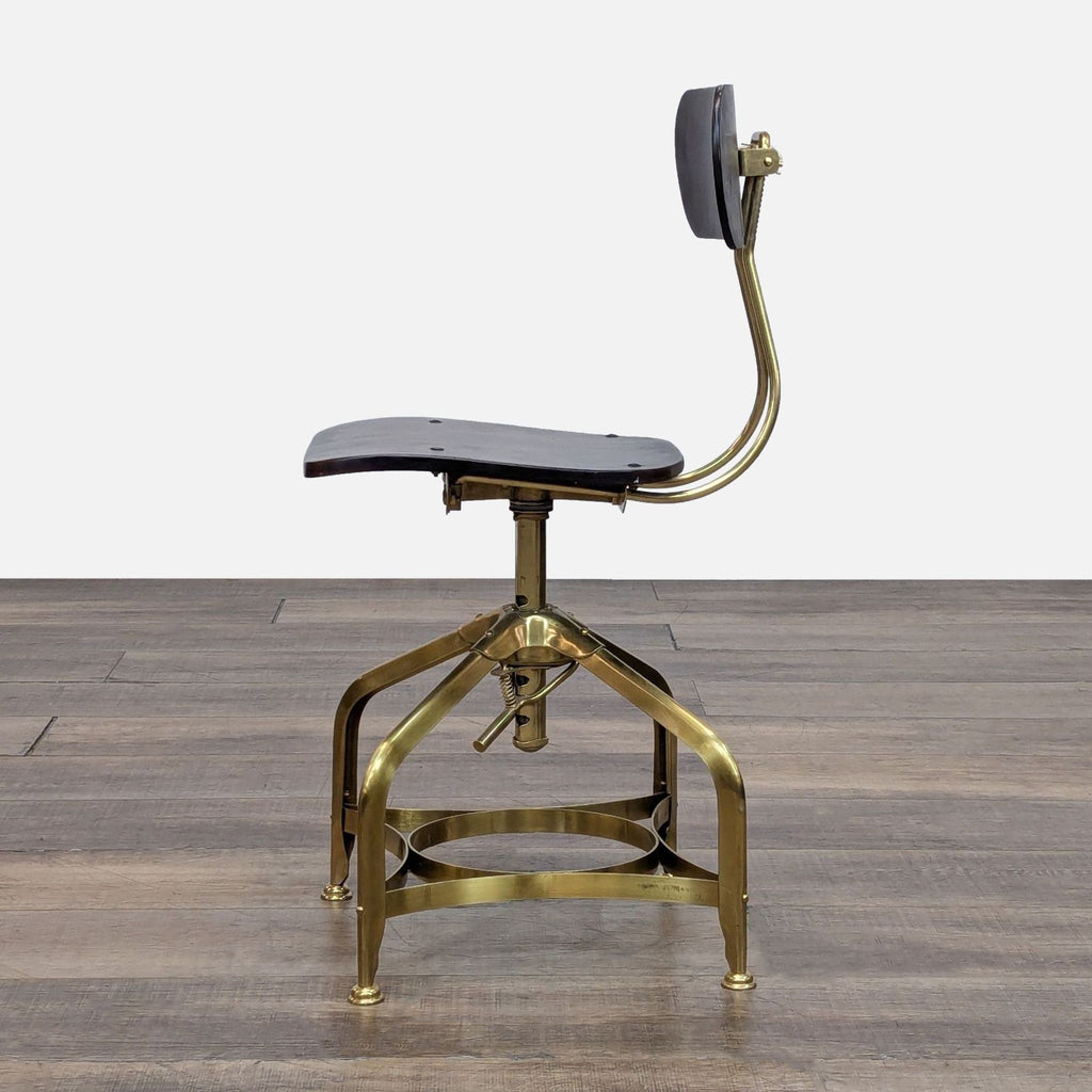 Side view of draftsman’s chair with brass frame, separate back adjustment, and wood seating.