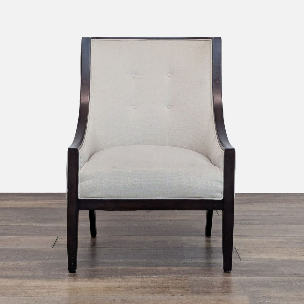 Front view of a Bloomingdale’s lounge chair with dark wood frame and tufted light fabric.