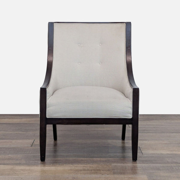 Front view of a Bloomingdale’s lounge chair with dark wood frame and tufted light fabric.