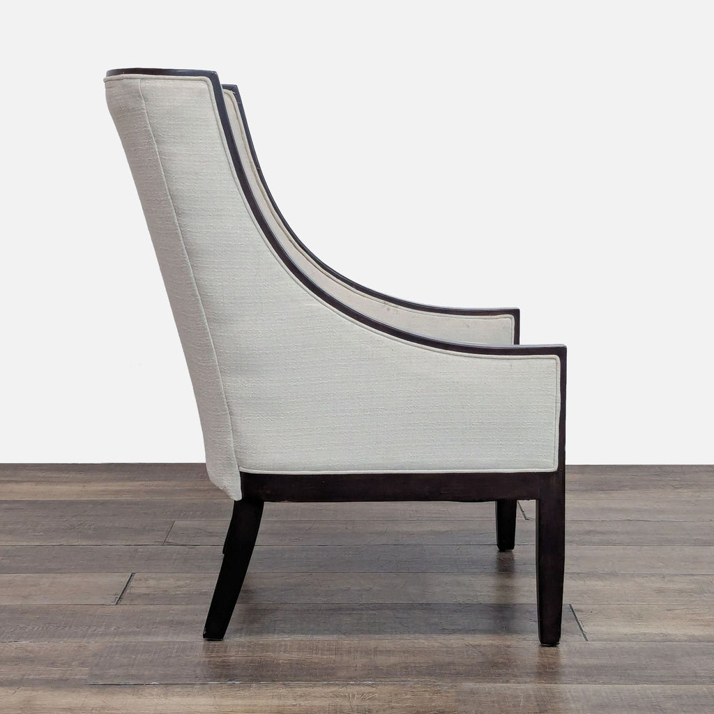 Side view of a Bloomingdale’s chair showcasing curved arms, high back, and dark wood frame.