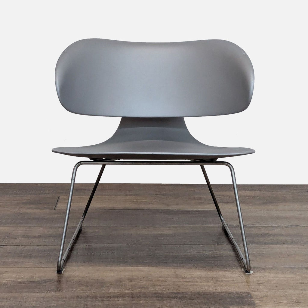 Sleek gray lounge chair with curved design on metal base.  