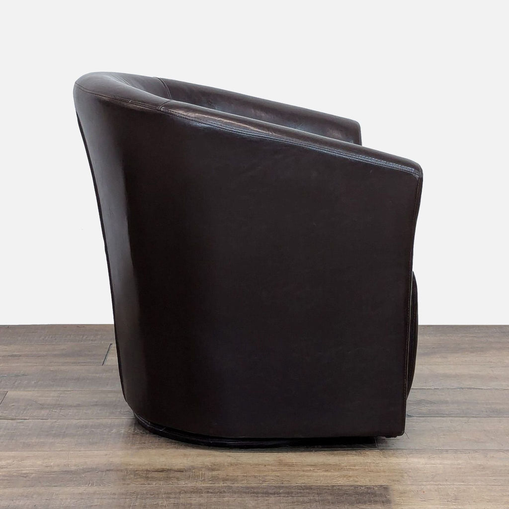 Side view of brown faux leather lounge chair with a barrel back design.