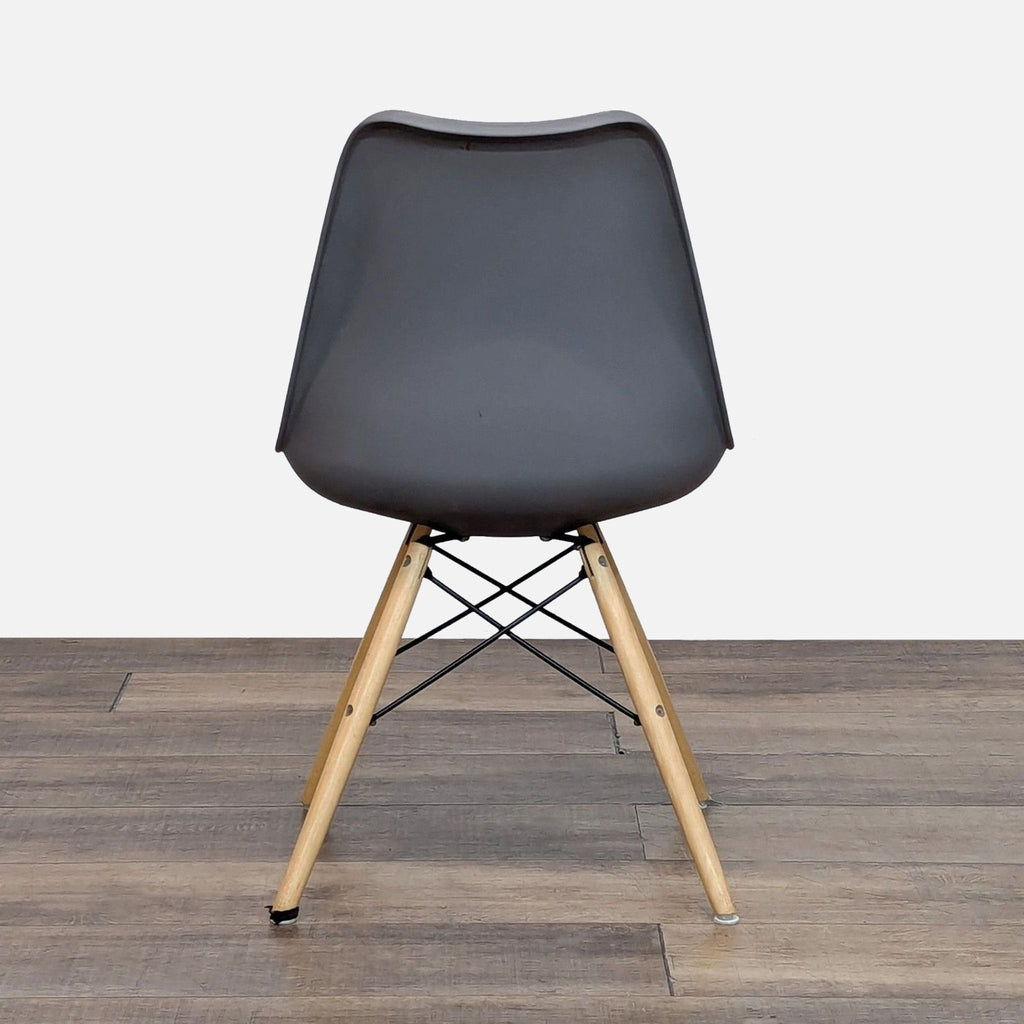 Back view of a plastic bucket seat dining chair, showcasing wood legs and metal support.