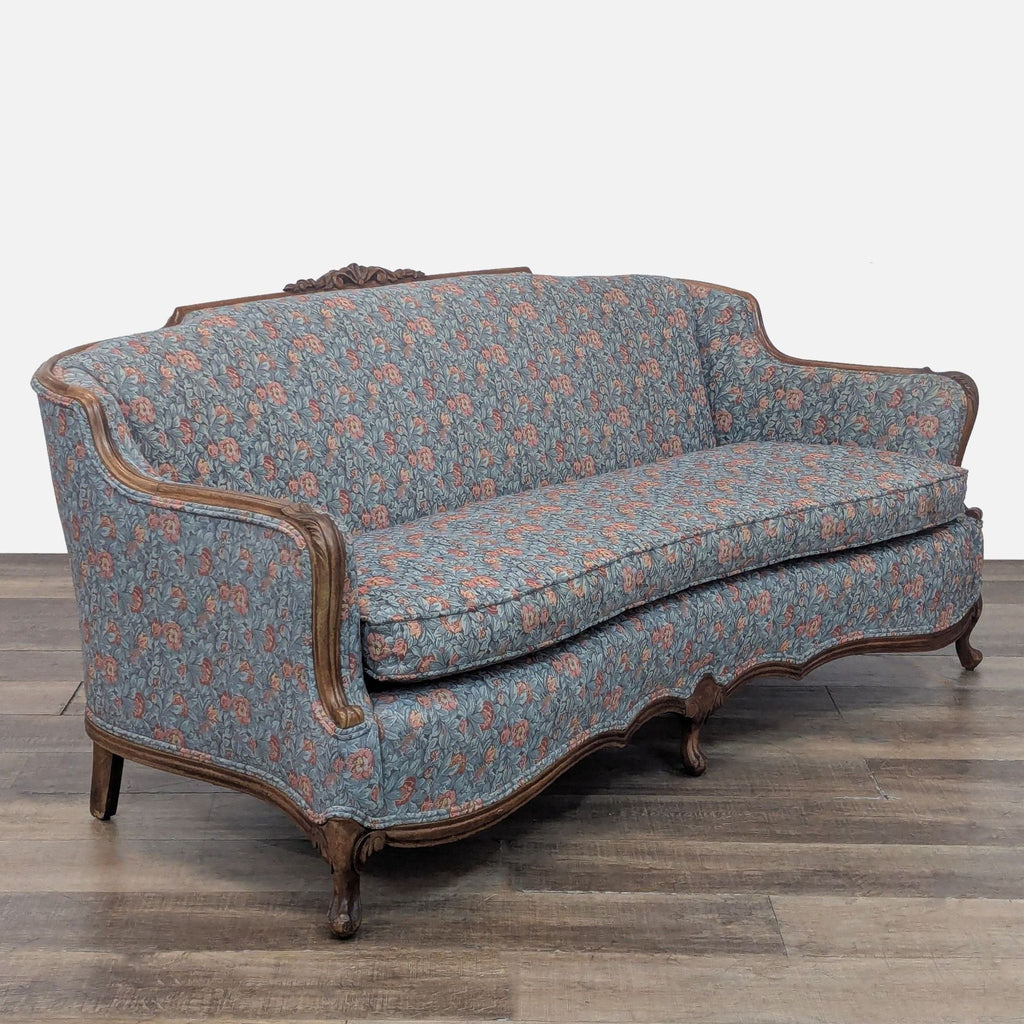 Angled view of Reperch 3-seat sofa with ornate woodwork and floral fabric.