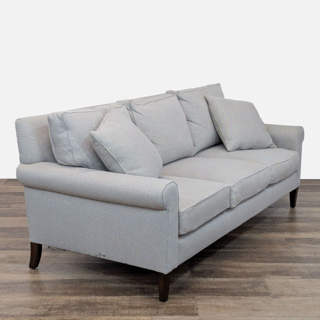 Angled view of a 3-seat Reperch sofa with loose back cushions, showcasing its wool herringbone upholstery.