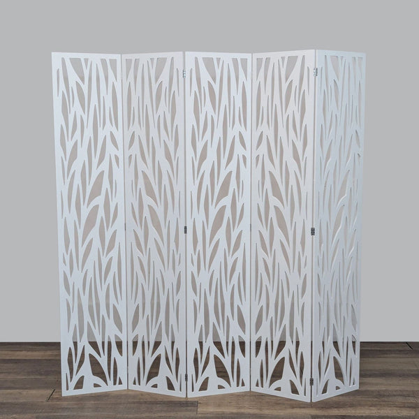 Folding white room divider with intricate leaf pattern design.   